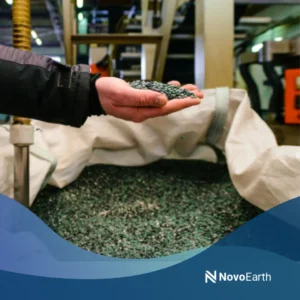 A worker holding biodegradable polymer granules in a manufacturing facility used for producing sustainable plastic materials.