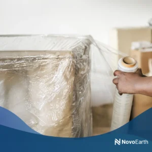 Biodegradable polymer sheet being used to wrap a large object, showcasing a sustainable alternative to conventional plastic in industrial applications